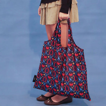 Person carrying a blue Eye of the Sun tote bag