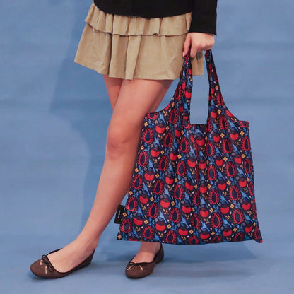 Person carrying a blue Eye of the Sun tote bag