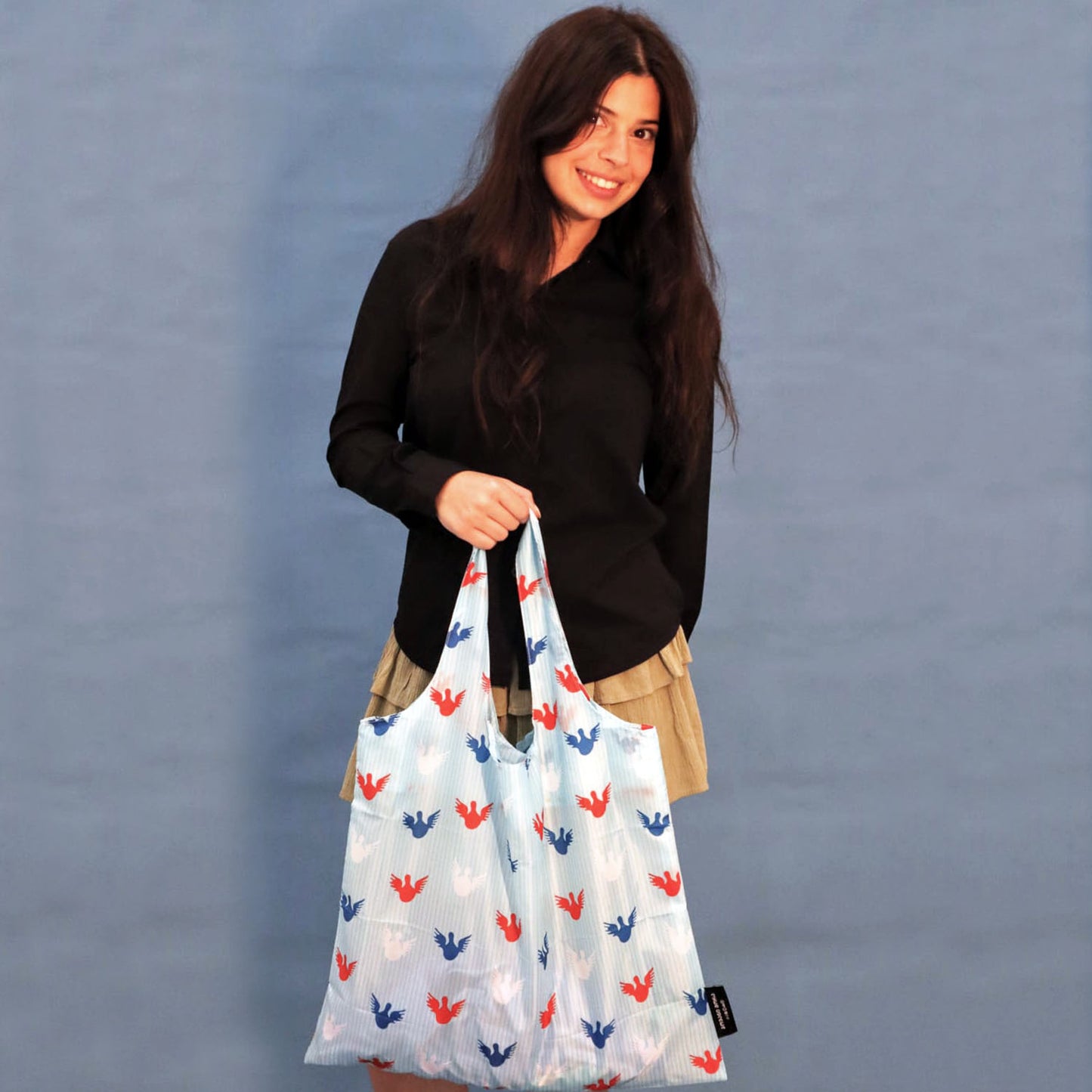 Person carrying a sky-blue Angels tote bag