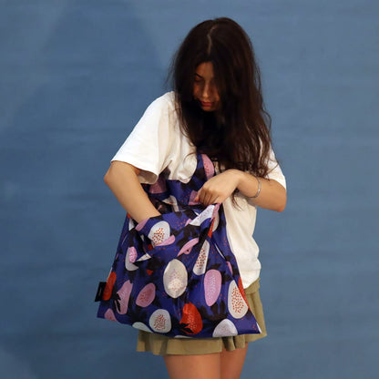 Person wearing a blue Papaya tote bag over the shoulder