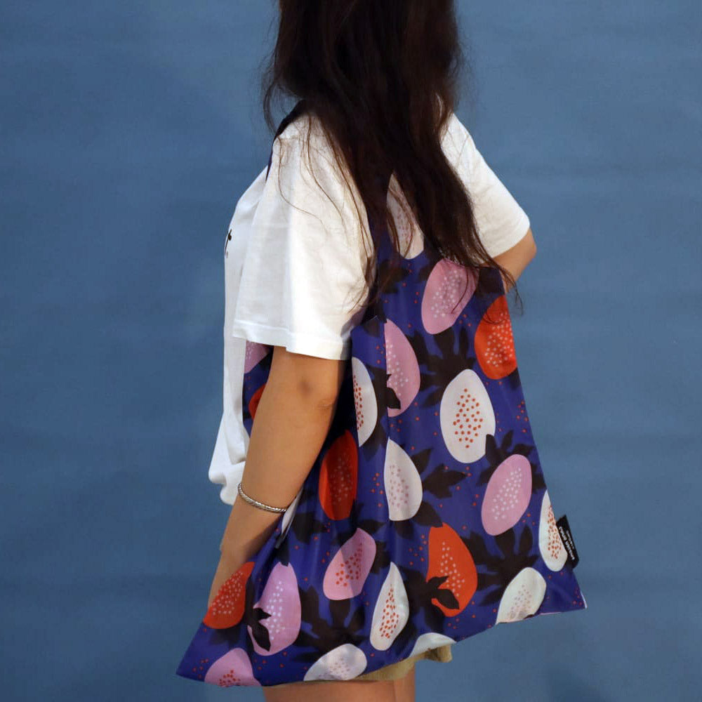 Person carrying a blue Papaya tote bag