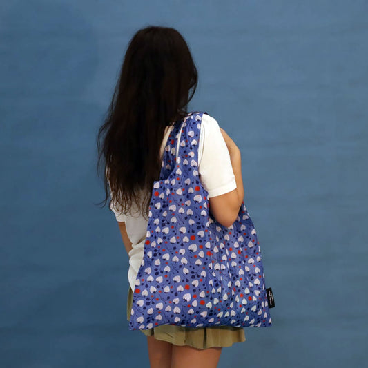 Person carrying a blue Strawberries tote bag
