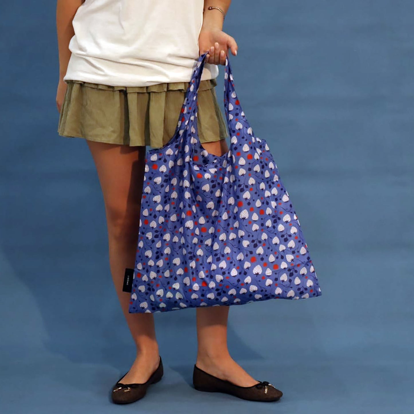 Person carrying a blue Strawberries tote bag