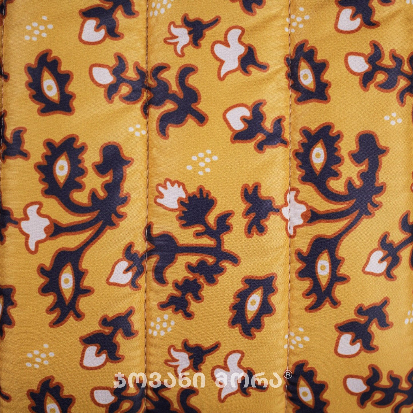 Close-up of Tholige Georgian ornament print on yellow padded laptop sleeve