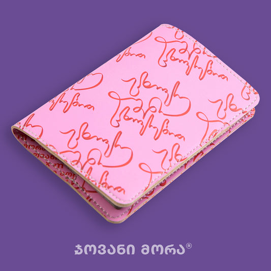 Angled view of folded pink and red Live Your Own Life passport holder