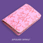 Angled view of folded pink and red Live Your Own Life passport holder