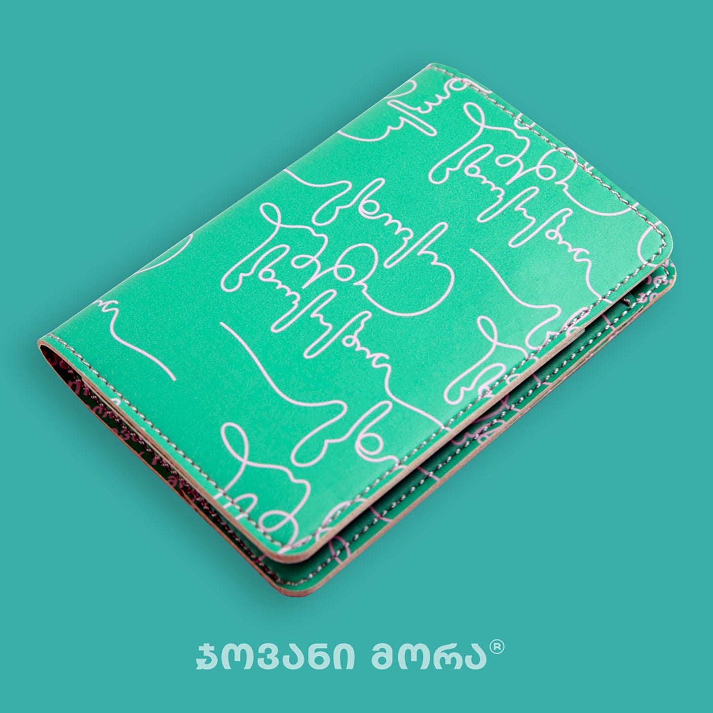 Angled view of folded green and pink Live Your Own Life passport holder