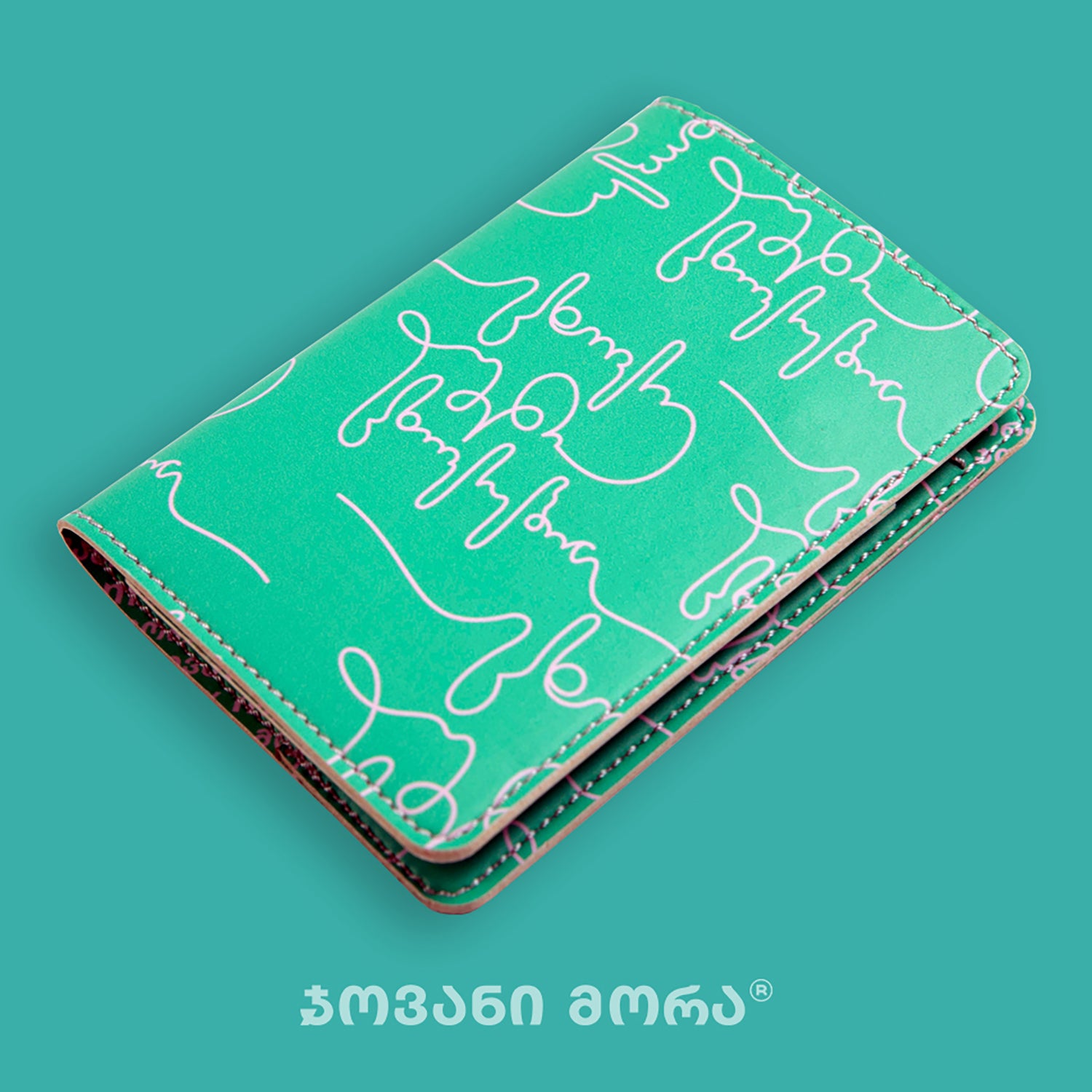 Angled view of folded green and pink Live Your Own Life passport holder