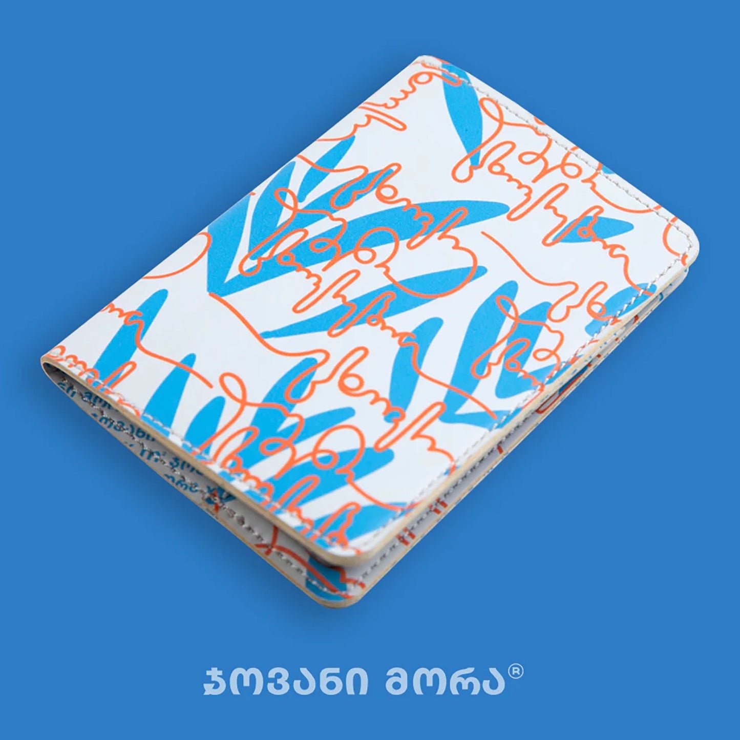 Angled view of folded beige and red Live Your Own Life passport holder