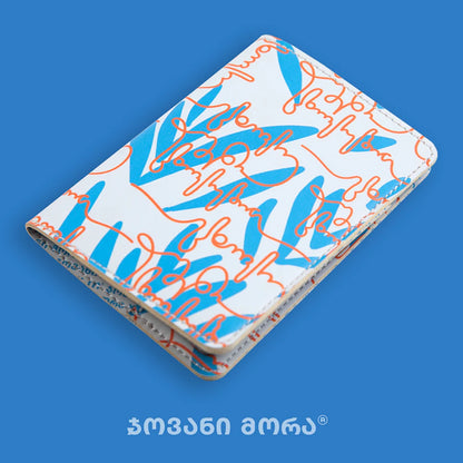 Angled view of folded beige and red Live Your Own Life passport holder