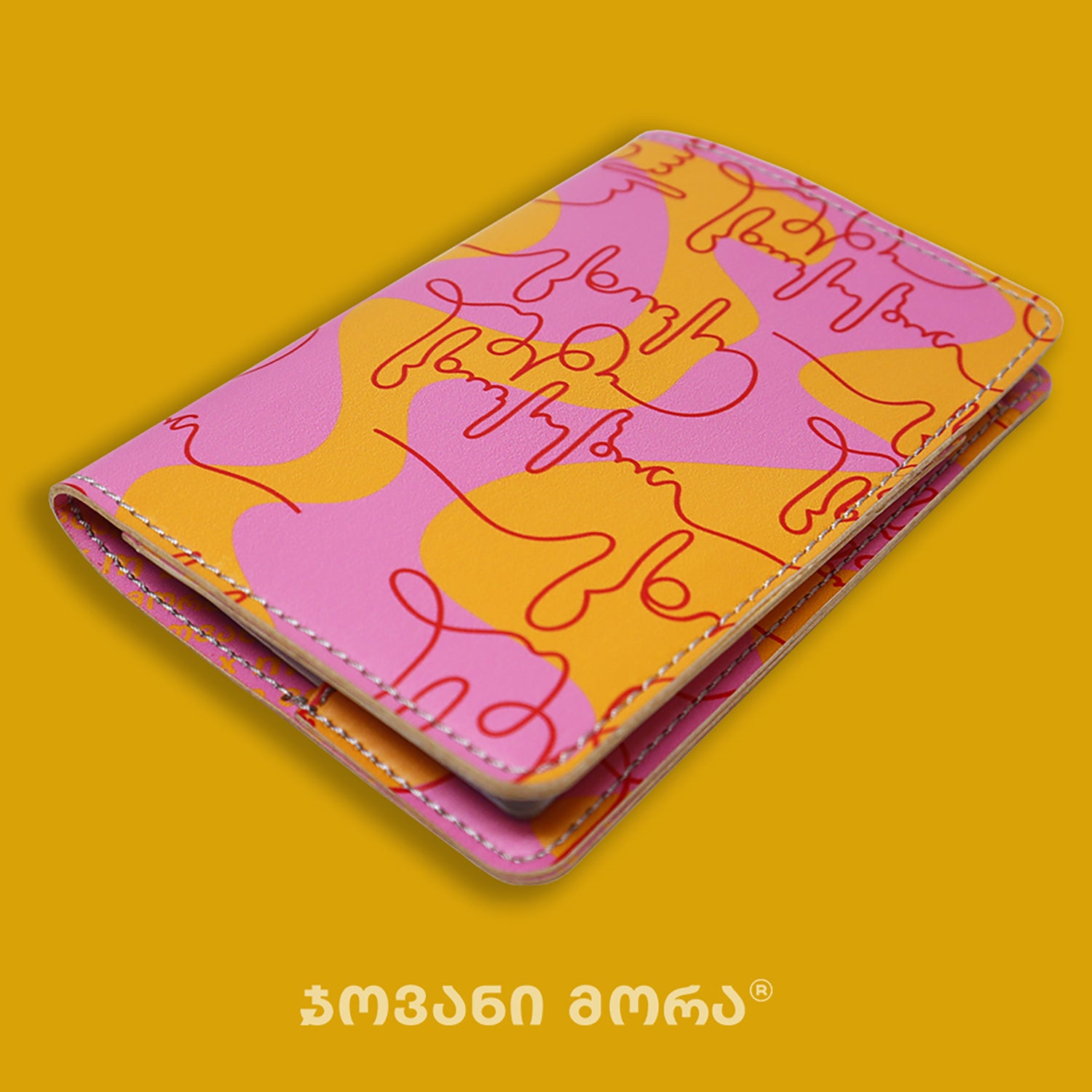 Folded pink, yellow, and red vegan leather passport holder with Live Your Own Life print by Giovanni Morra