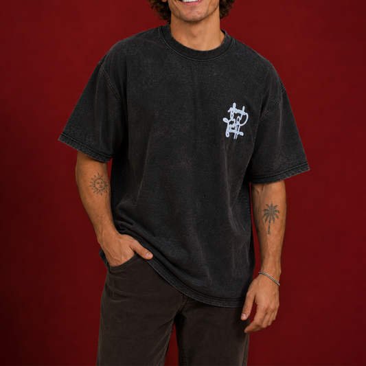 Person wearing a black acid-washed T-shirt with a sky-blue graphic