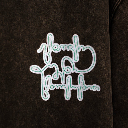 Close-up of a sky-blue graphic printed on black acid-washed cotton