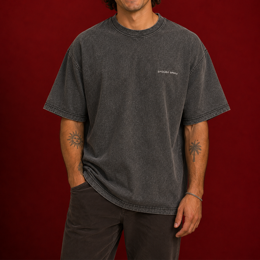 Person wearing a black acid-washed T-shirt with a tonal Georgian logo
