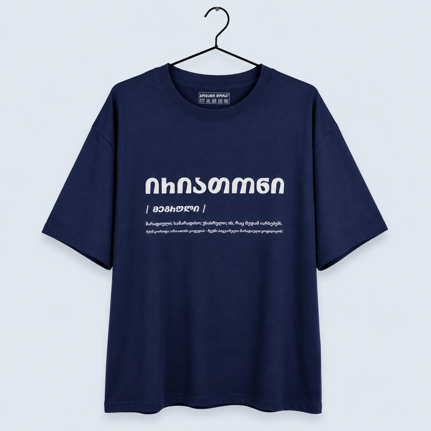 A navy blue short-sleeve t-shirt hanging on a black hanger against a light gray background. The shirt features white Georgian text printed on the chest.