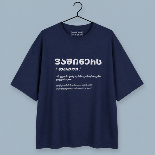 A navy blue short-sleeve t-shirt hanging on a black hanger against a light blue-gray background. The shirt features white Georgian text printed on the chest.
