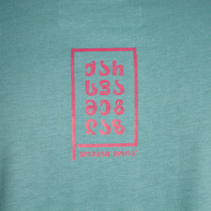 Close-up of a small red typographic graphic on the back of a pale green T-shirt